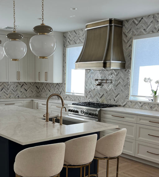 Antique brushed brass curved custom range hood with brushed stainless steel straps at rangehoodmaster