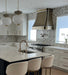 Antique brushed brass curved custom range hood with brushed stainless steel straps at rangehoodmaster