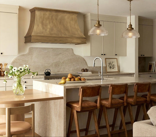 Handcrafted antique brass custom stove hood with crown molding detail in a luxury kitchen