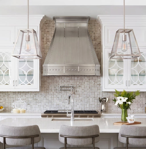 custom brushed stainless steel range hood with straps and rivets and clipped corners and crown molding at rangehoodmaster