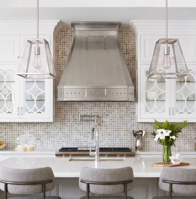 custom brushed stainless steel range hood with straps and rivets and clipped corners and crown molding at rangehoodmaster