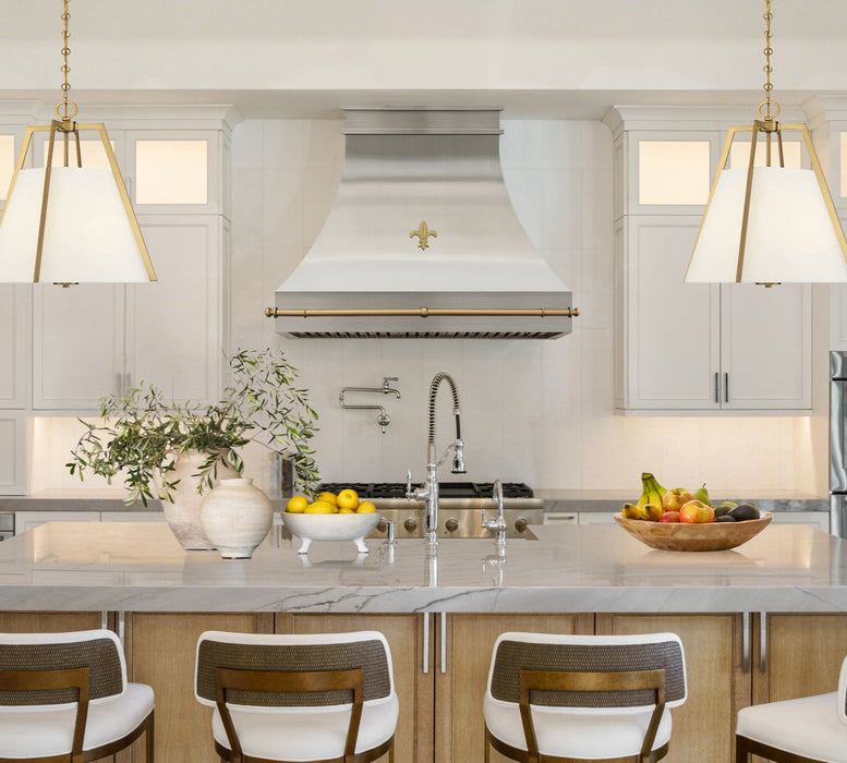 custom decorative metal range hoods in brushed brass finish with Fleur-de-Lis pattern and custom brass pot rail