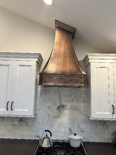 copper hood with medium copper finish and hand hammered apron, made to fit in sloping ceiling