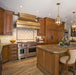 Luxury metal stove hood with rivet trim for classic transitional kitchen remodel