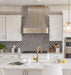Modern stainless steel range hood with golden decorative straps, crown molding and rivets at rangehoodmaster
