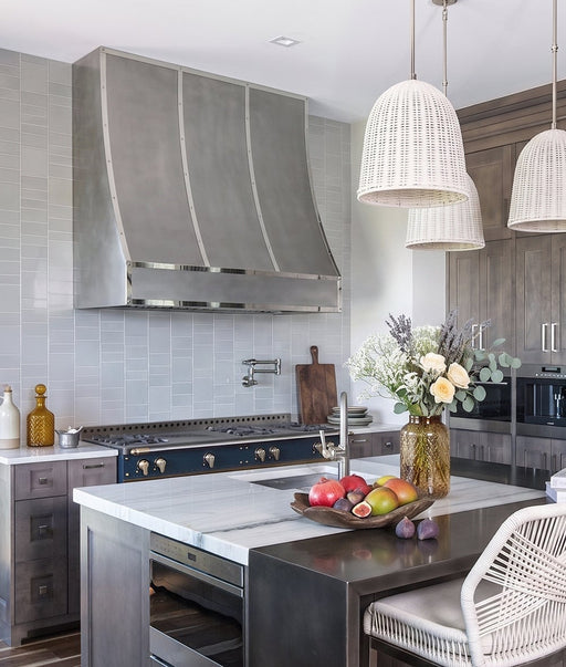 Handcrafted non-direction stainless steel sloped kitchen range hood with decorative polished stainless steel straps and rivets at rangehoodmaster