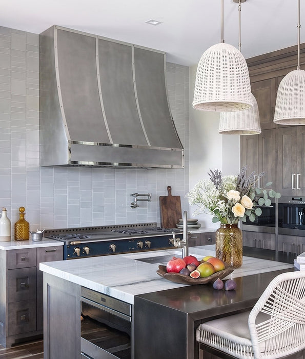 Handcrafted non-direction stainless steel sloped kitchen range hood with decorative polished stainless steel straps and rivets at rangehoodmaster