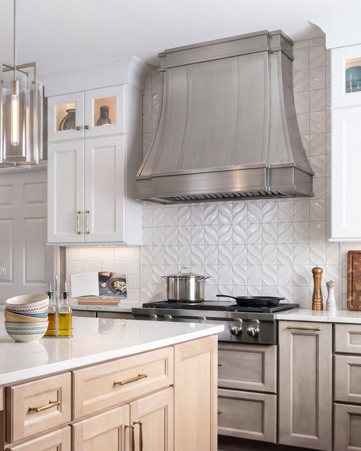 Modern curved stainless steel kitchen range hood with decorative stainless steel straps at rangehoodmaster