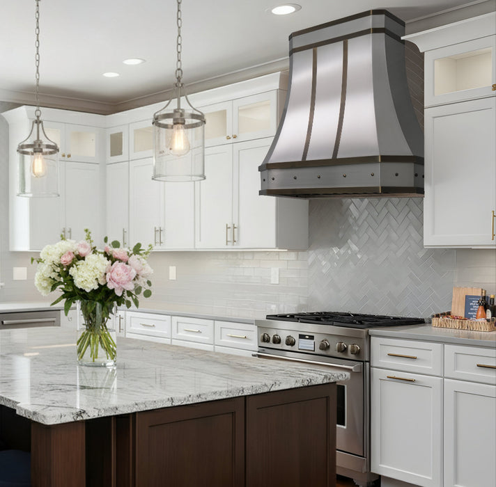 custom stainless steel range hood with antique brushed brass straps and round rivets