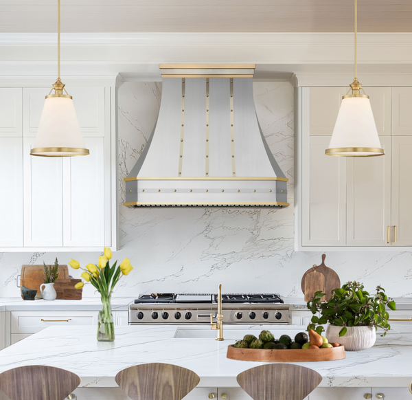 Stainless steel range hood with brushed brass straps and rivets and a simple modern crown molding from RangeHoodMaster