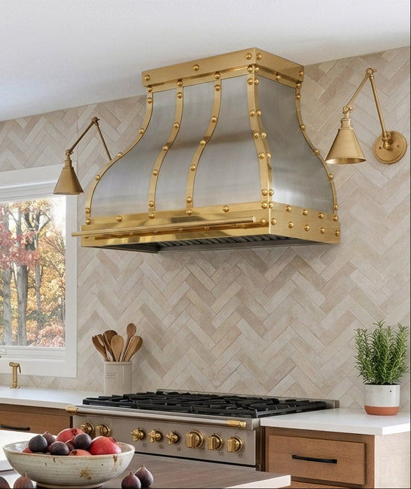 Custom brushed stainless steel bell range hood with golden polished brass straps rivets and pot rail handmade at rangehoodmaster