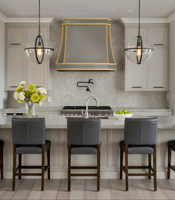 Custom metal range hood in kitchen made with pure zinc material and brushed brass straps and small round rivets