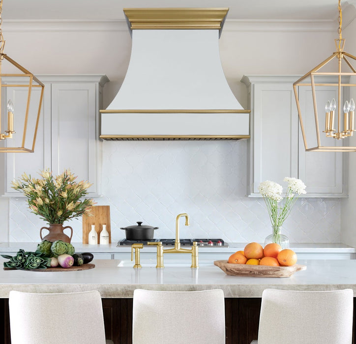 custom matte white stainless steel range hood with golden brass crown molding and trims from RangeHoodMaster