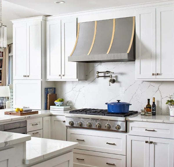 Custom stainless steel range hood sloped design with brushed brass straps at RangeHoodMaster